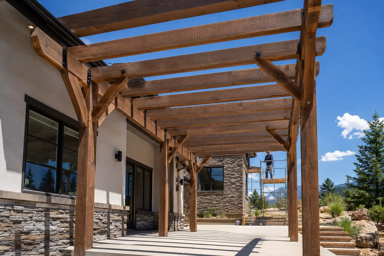 Timber pergola installation showing posts, beams, bracing, rafters, and safe scaffold access